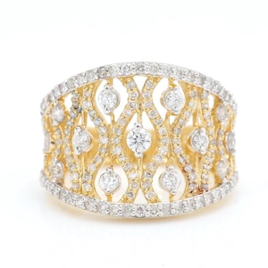 May include: A wide, ornate ring with a gold band and a detailed pattern of diamonds. The ring features a central row of larger diamonds, surrounded by smaller stones, creating a sparkling, luxurious appearance. The ring's design is intricate and eye-catching.