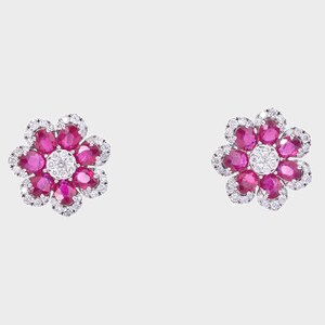 Puede incluir: Un par de pendientes con forma de flor. Cada pendiente presenta un grupo central de diamantes blancos redondos rodeado por un anillo de piedras preciosas rosas ovaladas. Los pétalos exteriores están delineados con pequeños diamantes claros.
