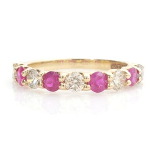 Könnte beinhalten: Ein goldener Ring mit abwechselnd runden Rubinen und Diamanten. Die Rubine sind leuchtend rosa und die Diamanten funkeln. Der Ring ist ein klassisches Design, geeignet für den täglichen Gebrauch oder besondere Anlässe.
