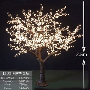 May include: A white artificial cherry blossom tree with lights, standing 2.5 meters tall. The tree has a brown trunk and branches with white blossoms. The tree is lit with white LED lights. The product details are listed below: LJ-S2484WW-2.5m, Height/Width 2.5*2.0m, Frequency 50/60 Hz, Power 240W, Voltage 24-240 V.