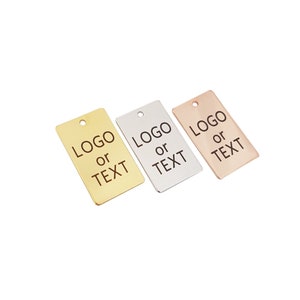 Op de afbeelding: Drie rechthoekige metalen labels met afgeronde hoeken. De labels zijn goud, zilver en roségoud. Elk label heeft de tekst "LOGO of TEXT" gegraveerd op de voorkant.