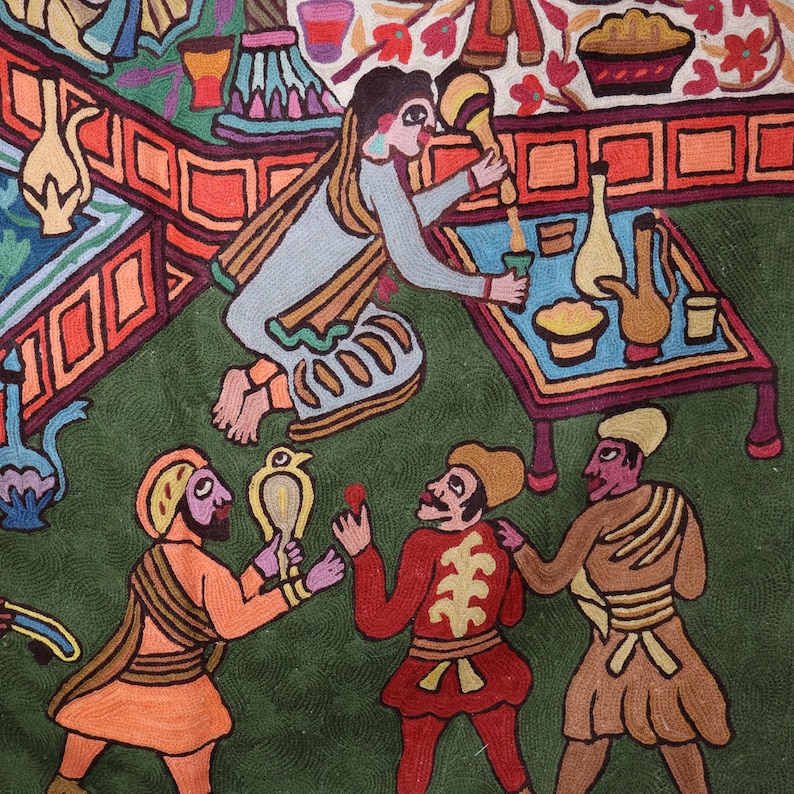 May include: A colorful embroidered artwork depicting a scene with multiple figures. The figures are dressed in various colors and patterns, including red, blue, green, and yellow. The artwork is set against a green background and features a table with a variety of objects, including a pitcher, a bowl, and a plate.