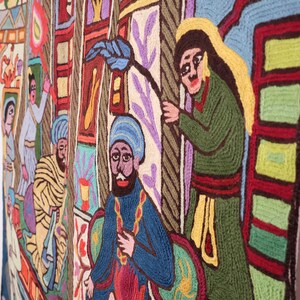 May include: A colorful tapestry with a scene of people in traditional clothing. The tapestry is made of yarn and features a variety of colors, including red, blue, green, yellow, and white. The people in the tapestry are depicted in a variety of poses, some standing, some sitting, and some walking. The tapestry is a beautiful example of traditional folk art.