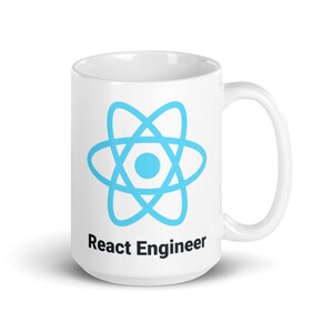 May include: White ceramic mug featuring a light blue React logo and the text "React Engineer" in black. The mug has a curved handle and a glossy finish. Ideal for a software developer.