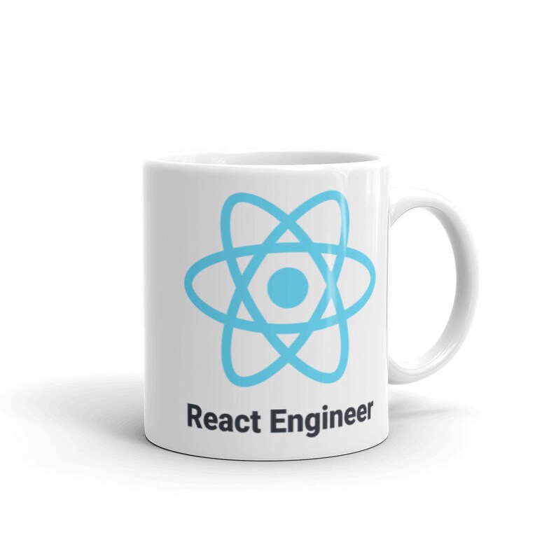 May include: White ceramic mug featuring a light blue atom symbol and the text "React Engineer" in black. The mug has a curved handle. Ideal for a software developer. The mug is set against a white background.