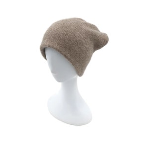 May include: A brown slouchy beanie hat made of soft knit fabric. The hat is on a white mannequin head.