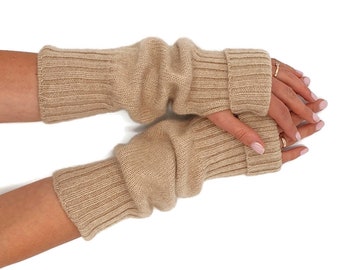 May include: A pair of beige knitted fingerless gloves. The gloves are made of a soft, warm material and are perfect for keeping your hands warm in the winter.