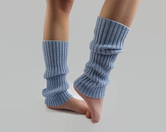 May include: A pair of light blue ribbed knit leg warmers. The leg warmers are made of a soft, textured material and are designed to be worn over the lower legs. The leg warmers are approximately 15 inches long.