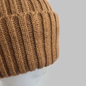 May include: A brown knitted beanie with a ribbed texture.