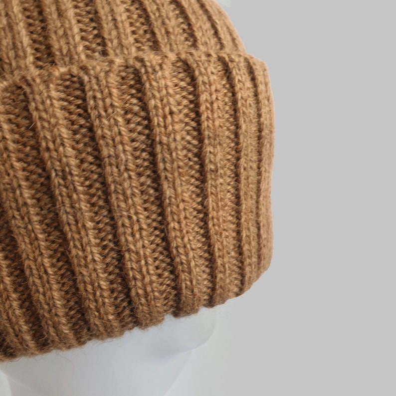 May include: A brown knitted beanie with a ribbed texture.