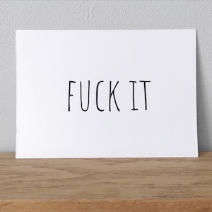 Op de afbeelding: Witte kaart met de tekst "FUCK IT" in het zwart.