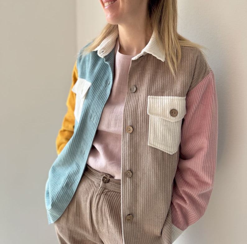 May include: A brown corduroy shirt with a blue, white, and yellow patchwork design. The shirt has a white collar and a button-up front.