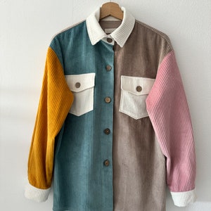 May include: A multi-colored corduroy shirt with a button-up front and long sleeves. The shirt is made of a patchwork of different colors, including teal, brown, white, and yellow.