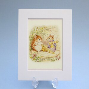 May include: Framed print with a watercolour illustration of two mice. One is brown and white, the other wears a blue waistcoat. They are amidst wheat and greenery, set against a light background, in a white mount.