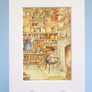 May include: A matted art print featuring a detailed watercolor illustration of two anthropomorphic mice in a rustic kitchen. One mouse stands on a wooden ladder reaching for shelves, while the other sits in a wooden chair near a stone fireplace.