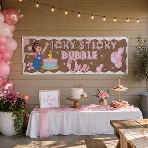 Pode incluir: Cena de festa de aniversário com balões cor-de-rosa, uma faixa com a frase "Icky Sticky Bubble One", um bolo e arranjos florais. Uma mesa está montada com guloseimas e uma placa com a frase "so sweet". Decorado com luzes.