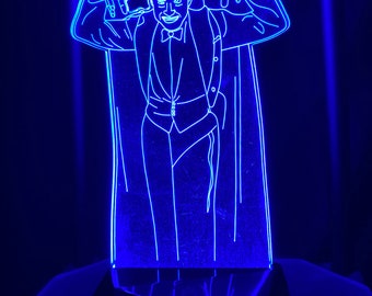 May include: A blue neon light sculpture of a man in a suit and cape, with his arms raised in a spooky pose.