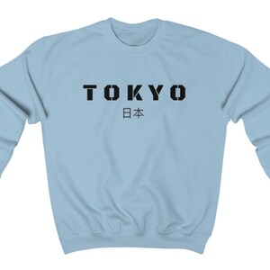 May include: Light blue sweatshirt with black text that reads "TOKYO 日本" (Tokyo, Japan).