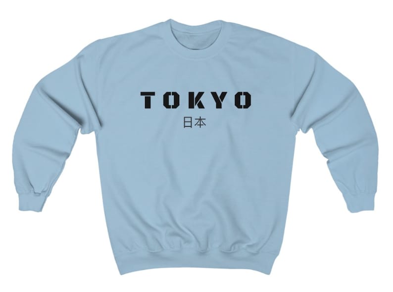 May include: Light blue sweatshirt with black text that reads "TOKYO 日本" (Tokyo, Japan).