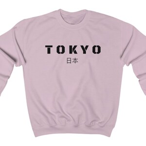 May include: A light pink sweatshirt with the word "TOKYO" in black block letters and the Japanese word for Japan, "日本", underneath.