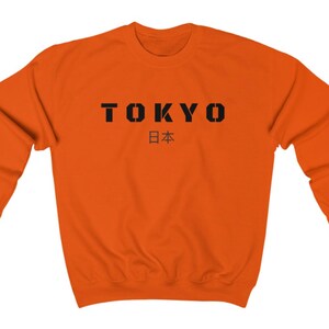 May include: Orange sweatshirt with black text that reads "TOKYO 日本" (Japan in Japanese).