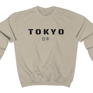 May include: A beige sweatshirt with black text that reads "TOKYO 日本".
