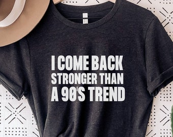 May include: Dark grey heather t-shirt with white text that reads "I come back stronger than a 90's trend".
