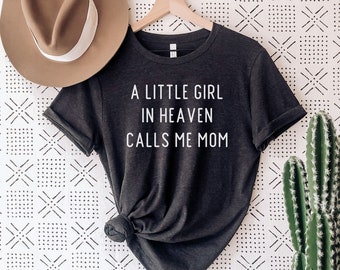 Könnte beinhalten: Ein T-Shirt aus dunkelgrauem Heather-Material mit dem in Weiß gedruckten Text "A little girl in heaven calls me mom".