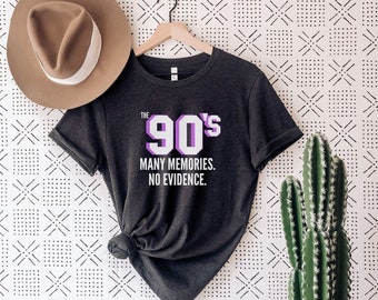 May include: Dark grey heather t-shirt with a white graphic that says "The 90's Many Memories. No Evidence."