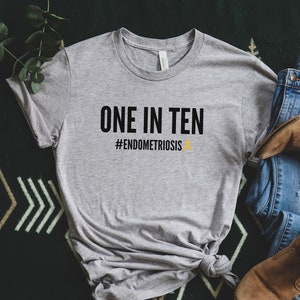 May include: Gray t-shirt with the text "ONE IN TEN #ENDOMETRIOSIS" in black with a yellow ribbon.