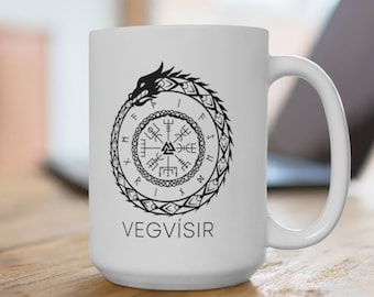 May include: White ceramic mug featuring a black Vegvísir symbol, a Viking compass, encircled by a dragon. The word "VEGVÍSIR" is printed below the symbol. The mug has a large handle and is set on a wooden surface.