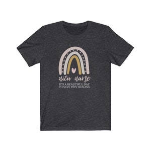 May include: A dark heather grey t-shirt with a rainbow graphic and the text "NICU nurse it's a beautiful day to save tiny humans".