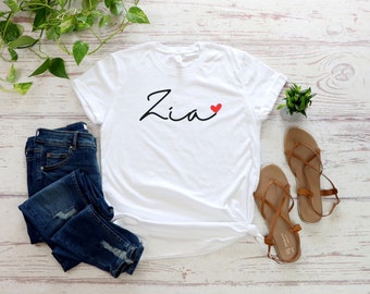 Könnte beinhalten: Weißes T-Shirt mit dem Namen "Zia" in schwarzer Schrift und einem kleinen roten Herz daneben.