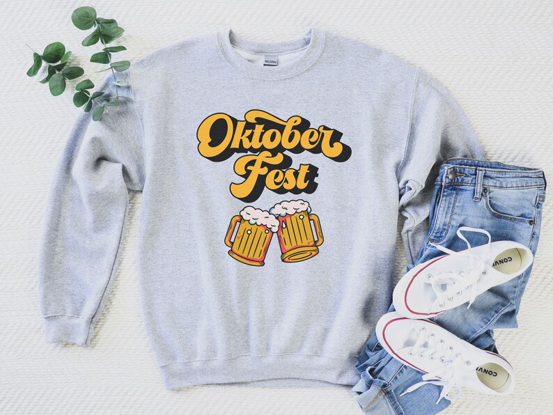May include: A gray sweatshirt with the text "Oktober Fest" in a retro font and a graphic of two beer steins with foam on top.