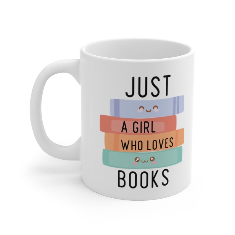 Op de afbeelding: Witte keramische mok met een zwart-wit ontwerp met de tekst "Just a girl who loves books". Het ontwerp toont een stapel kleurrijke boeken met schattige gezichten.
