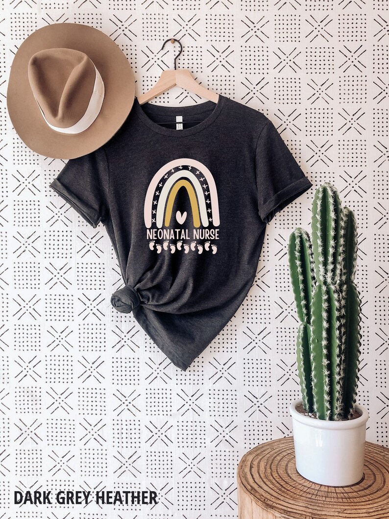 May include: Dark grey heather t-shirt with a rainbow graphic and the text "Neonatal Nurse" with a heart and baby footprints.