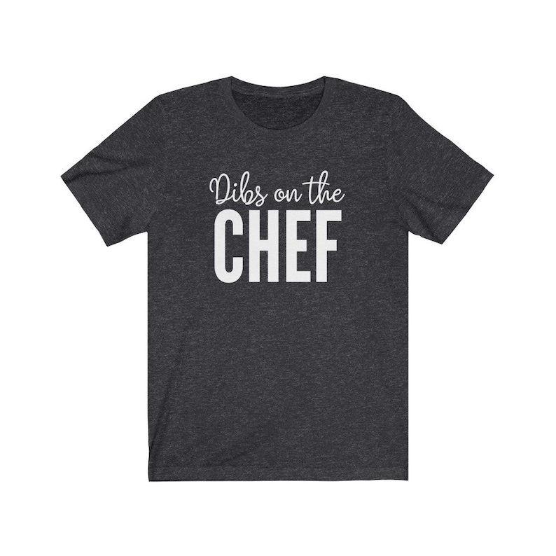 May include: A dark heather grey t-shirt with the text "Dibs on the CHEF" printed in white.