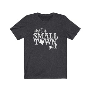 May include: A dark heather grey t-shirt with the text "just a small town girl" and an outline of the state of Texas.
