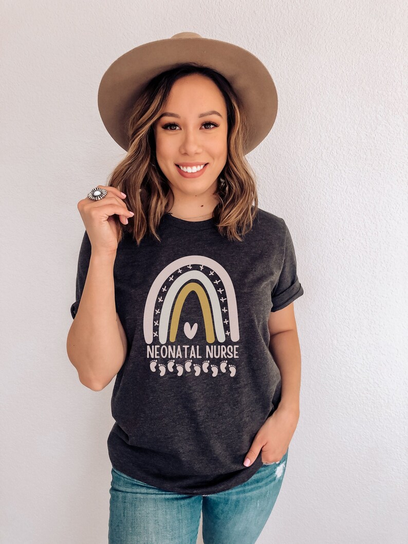 May include: A dark grey t-shirt with a rainbow design and the text "Neonatal Nurse" with a heart and footprints.
