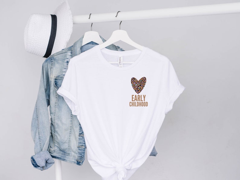May include: White t-shirt with a brown leopard print heart and the text "EARLY CHILDHOOD" in brown.