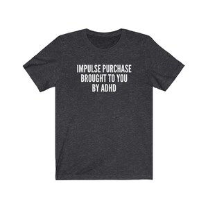 Puede incluir: Camiseta gris oscuro jaspeada con texto blanco que dice "Impulse purchase brought to you by ADHD".