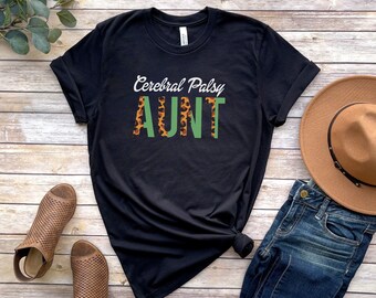 May include: Black t-shirt with the text "Cerebral Palsy AUNT" in white with green and leopard print accents.