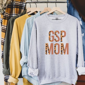 May include: Gray sweatshirt with the text "GSP MOM" in orange letters with a leopard print pattern.