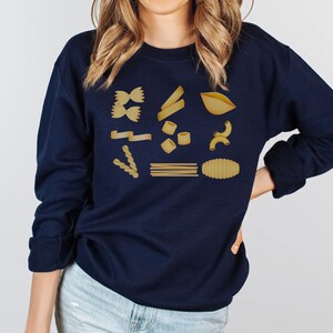 Op de afbeelding: Een donkerblauw sweatshirt met een afbeelding van verschillende soorten pasta in goud.