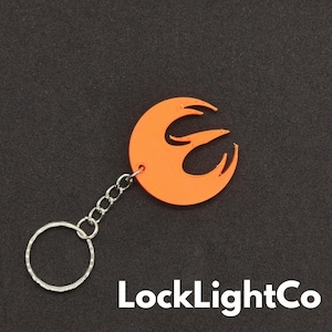 May include: Orange plastic keychain with a Rebel Alliance symbol and a silver chain.