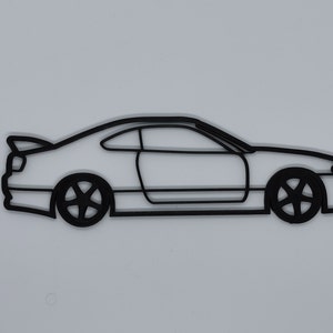 May include: A black line drawing of a coupe car on a white background.