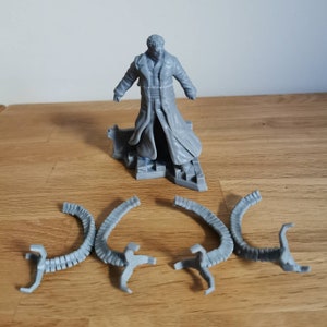 May include: A gray 3D printed figurine of a man in a long coat, standing on a base with a textured surface. Four gray 3D printed tentacles are also included.