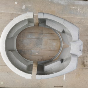 May include: Two gray plastic pieces that fit together to form a helmet. The pieces are separated and show the inside of the helmet.