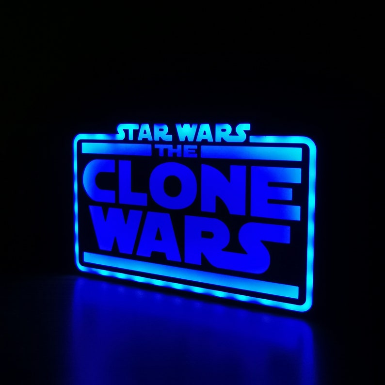以下が含まれることがあります： 白い輪郭で「スター・ウォーズ クローン・ウォーズ」という文字が書かれた青いネオンサイン