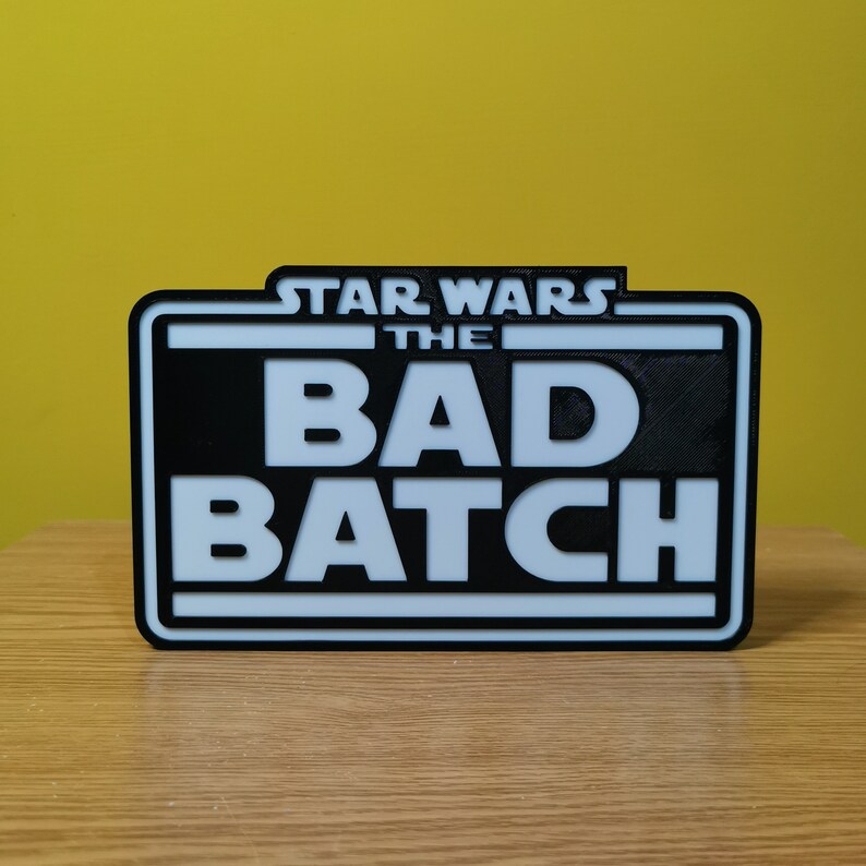 May include: A black and white sign with the text "STAR WARS THE BAD BATCH" in white letters on a black background.